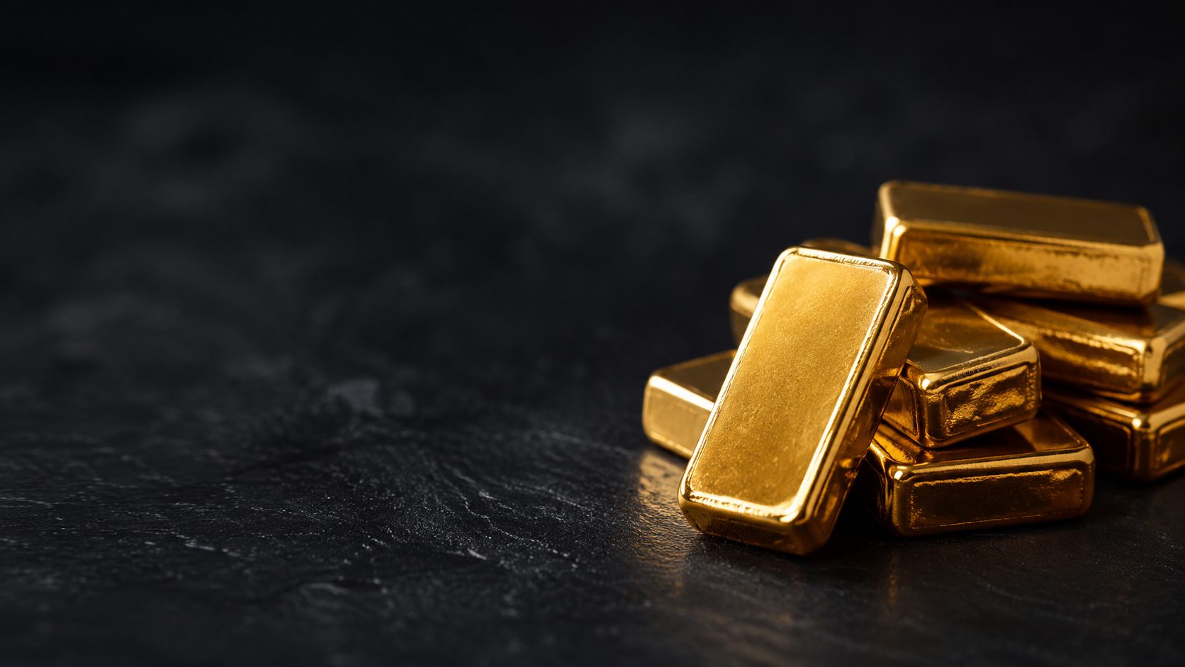 Lingotes de oro de inversión sobre superficie oscura